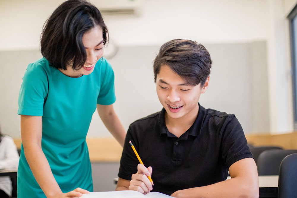 tutoring-high-school-asian-student-with-teacher